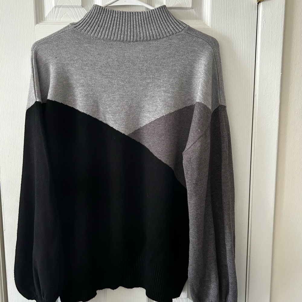Woman’s Gray and Black turtleneck sweater.